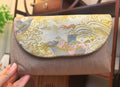 Gilded Brocade Metal‑Element Clutch Bag